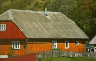 The texture of the roof with shiver slate coating. Rough and old roof of gray slate wavy sheets. Waterproof roofing from asbestos material photo