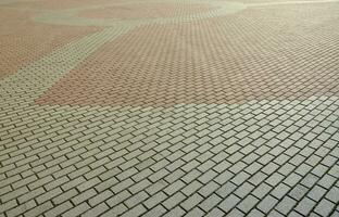 A large area, covered with a quality paving stone in daylight photo