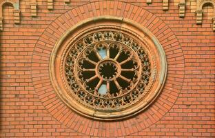 Texture front part of an ancient brick crypt with a round patterned carved window in the cemetery photo