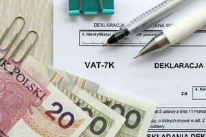 Declaration for tax on goods and services VAT-7K form on accountant table with pen and polish zloty money bills photo