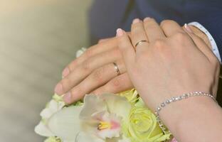 The newlywed couple is holding a beautiful wedding bouquet. Classical wedding photography, symbolizing unity, love and the creation of a new family photo