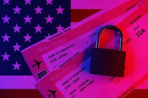 Fictional air tickets and small padlock on United States of America flag photo