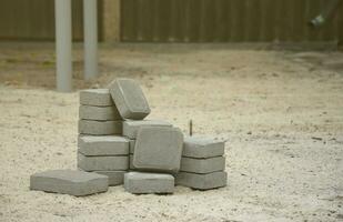 Small pile of gray walkway slabs lying in stack outdoors. Material for Paving Slabs by mosaic in progress. Cobblestone installation photo