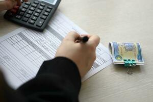 Accountant start to fill Iranian tax form on office table. Taxation period and annual taxpayers routine photo