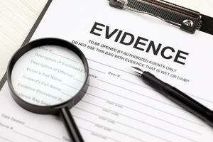 Evidence report blank on A4 tablet lies on office table with pen and magnifying glass photo