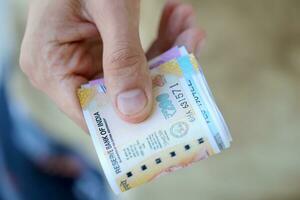 hombre mano con indio rupias facturas. concepto de financiero operaciones en efectivo en India foto