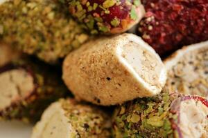 Rolls of turkish delight with many different flavors and fillings close up on table of vendors market photo