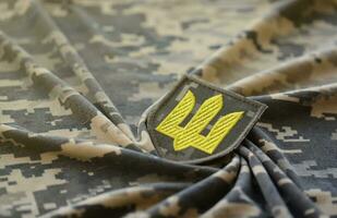 símbolo de ucranio Ejército en el camuflaje uniforme de un ucranio soldado. el concepto de guerra en Ucrania, patriotismo y proteger tu país desde ocupantes foto