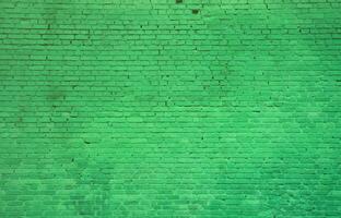 The texture of the brick wall of many rows of bricks painted in green color photo