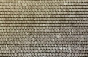 Gray wooden roof tiles background texture. A close up of old gray roof covered with wooden tiles photo