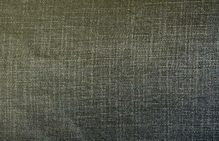 Detailed abstract texture of dark blue denim cloth. Background image of old used denim trousers fabric photo