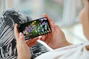 Fantasy Westward Journey mobile iOS game on iPhone 15 smartphone screen in female hands during mobile gameplay photo