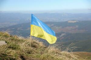 Ukrainian flag on top of Hoverla mountain in Ukraine photo