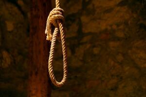 Noose in prison of old castle cellar and grunge stone wall photo