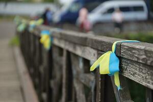 Ribbons in the colors of the national flag of Ukraine are tied to the handrail photo