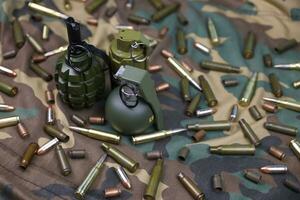 Different types of ammunition on a camouflage background. Preparing for war photo