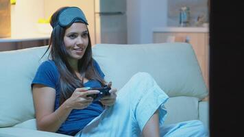 jugador utilizando palanca de mando jugando vídeo juegos en consola sentado en sofá en vivo habitación. emocionado determinado mujer utilizando controlador gamepad teclado estación de juegos juego de azar y teniendo divertido victorioso electrónico juego foto