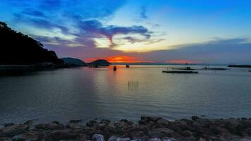 zonsondergang reflecteren Aan zee tegen kleurrijk lucht video