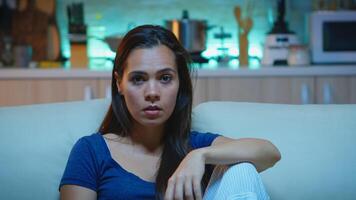 Woman watching television show very concentrated and amazed. Lady with surprised face emotionally awestruck and wide-eyed reacting to an impressive and astonishing moment sitting on comfortable couch photo