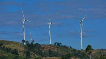 turbines of solar panels rotating on mountains againts sky video