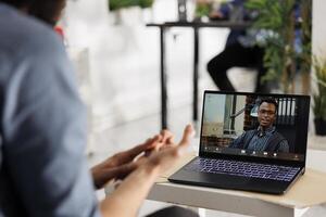 empresario colaborando con equipo líder en proyecto en virtual espacio de trabajo mediante vídeo llamar. empleado presentación negocio plan a empresa CEO en en línea reunión en portátil computadora foto