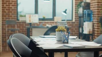 Boardroom meeting place with desks in empty agency office, coworking space filled with workstations and official documents. International startup workplace used for analysis and reviewing work. photo