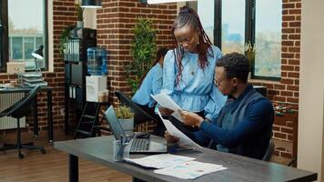 Coworkers team examining documents in office and planning new business development, reading annual data results to increase profit. People examining analytics in coworking space. photo