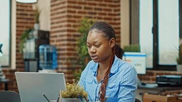 Female worker creating project research to increase business profit, using online results and analytics to work on new vision. Woman manager reading annual data reports on papers. photo