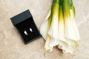 wedding rings and a bouquet of lilies photo