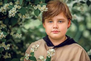 A young handsome boy of European appearance poses in bloom in nature. Not staged portraits of a boy. It's a great time to relax. photo