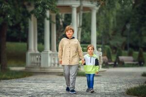 Two brothers, two Young handsome boys of European appearance, enjoy spending time on the street. It's a great time to relax. photo