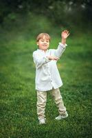 A young handsome boy of European appearance enjoys spending time on the green lawn at home. It's a great time to relax. photo