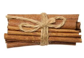 Dry cinnamon sticks tied with brown jute rope on a white isolated background photo