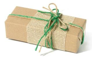 The box is packed in brown craft paper and tied with a rope on a white background photo