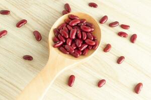 red kidney beans and spoon on wooden background, top view, flat lay, top-down, selective focus. photo