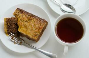 Caramel Peanut Topped Brownie Cake and a Cup of Tea photo