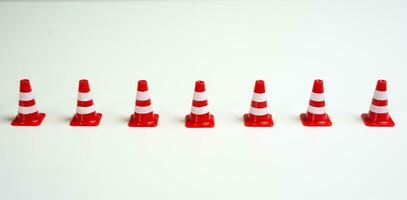 Row of traffic cones on a white background. Create a new restriction. Provide new sanctions and restrictions. Laws and regulations. Bans and taboo. Stop work, freeze and cancel. Block VPN services. photo