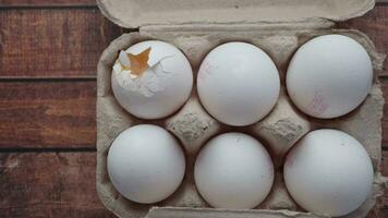 one broken egg with yellow yolk stored in carton container video