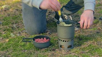 Man in a Forest is Cooking Pasta With Canned Stew Using a Small Cook Set. Tourist in a Hike is Prepearing for the Lunch. CloseUp View, Static Shot video