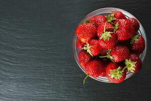 Strawberry in a bowl on black backround photo