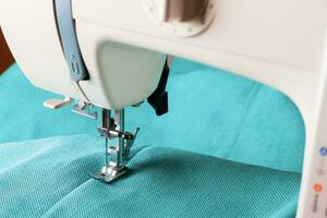 Modern sewing machine and turquoise fabric photo