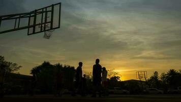 mensen zijn spelen basketbal Bij zonsondergang tijd video