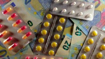 inflación. costoso medicamento. alto costo de cuidado de la salud. global farmacéutico industria y medicinal productos de colores pastillas y cápsulas en el veinte euro billetes - parte superior vista, rotación Derecha video