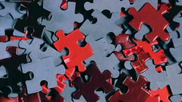 Background of Colored Puzzle Pieces that Slowly Rotating Counterclockwise - Top View, Close-Up. Texture of Incomplete Red and Grey Jigsaw Puzzle - Left Rotation video