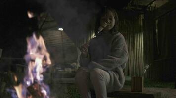 ett liten asiatisk flicka rostad marshmallow grillar i de flamma på bål, en natt camping utflykt semester, natur inlärning erfarenhet, utomhus- livsstil Semester, och landsbygden äventyr resa. video