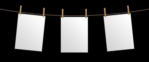 Empty paper sheet hanging on rope, isolated on black background, mock up for your project, poster template photo