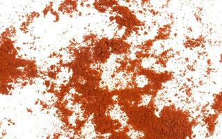 Scattered red paprika powder isolated on white background. Top view photo
