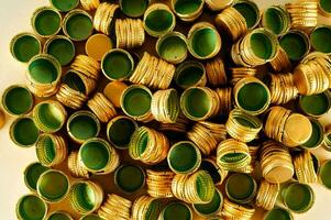 a pile of green and gold bottle caps photo