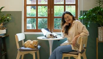 woman working from home with cat. cat asleep on the laptop keyboard. assistant cat working at Laptop photo