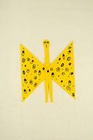a yellow paper butterfly with black dots on it photo